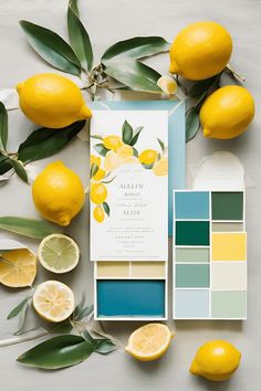 the wedding stationery is laid out with lemons and greenery