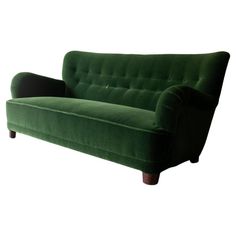 a green couch sitting on top of a white floor