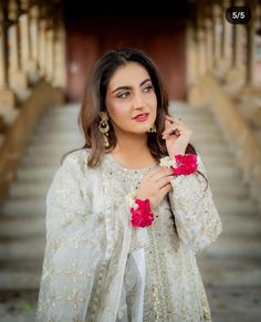 a beautiful woman in white dress posing for the camera