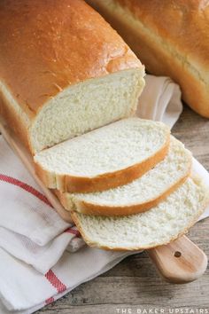 a loaf of white bread sitting on top of a wooden cutting board