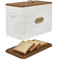 two slices of bread sitting on top of a cutting board next to a white bread box