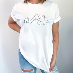 Mountain Art T-Shirt | Nature-Inspired Apparel Welcome to our collection of nature-inspired apparel, where art meets adventure! Introducing our Majestic Mountain Art T-Shirt, designed to capture the breathtaking beauty of the mountains and bring it to life in wearable art. Immerse yourself in the awe-inspiring beauty of the mountains with this unique t-shirt.  About your shirt:  .: 100% Airlume combed and ringspun cotton (fiber content may vary for different colors)  .: Light fabric (4.2 oz/yd² Nature-inspired Relaxed Fit Short Sleeve Tops, Nature-inspired Cotton Tops With Graphic Print, Nature-inspired Crew Neck Tops With Screen Print, Nature-inspired Graphic Print Crew Neck Top, White Graphic Print Top For Outdoor, White Relaxed Fit Outdoor Tops, White Relaxed Fit Top For Outdoor, White Graphic Tee For Outdoor, White Graphic Print Tops For Outdoor Activities