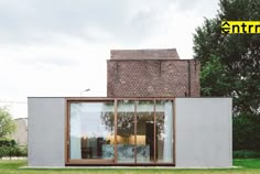 a house that is made out of concrete and has glass doors on the front door