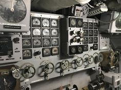 there are many controls on the wall in this ship's control room that is full of dials and gauges