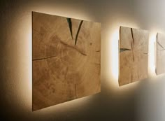 three pieces of wood are hanging on the wall next to each other, with light shining through them