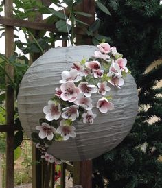 a paper lantern with flowers hanging from it