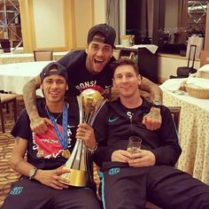 two men sitting next to each other holding trophies in their hands and smiling at the camera