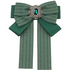 a green bow with a brooch on it's end and an emerald stone in the center