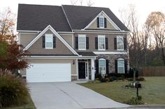 a house with brown siding and white shutters