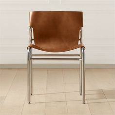 a brown leather chair sitting on top of a hard wood floor