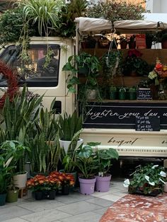 an old van is covered with potted plants