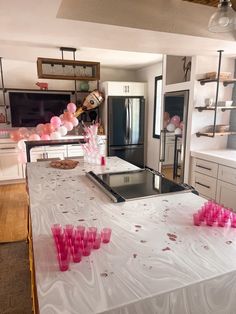 a kitchen filled with lots of white counter tops and pink cups on top of it