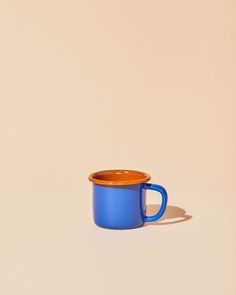 a blue and orange cup sitting on top of a table