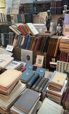 many books are stacked on top of each other in front of a store display case