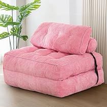 a pink couch sitting on top of a hard wood floor next to a plant in a living room