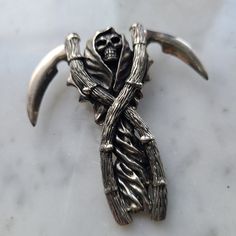 a silver brooch with a skull on it