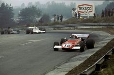 two racing cars on a race track with people watching