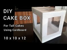 a white cake box sitting on top of a table next to a black countertop