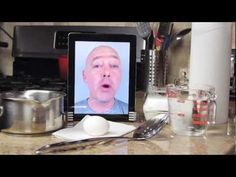 an image of a man's face on the screen of a tablet computer next to utensils