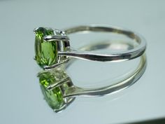 This is a beautiful Peridot from Pakistan set in Sterling Silver. This amazing stone has the perfect lime green color that many want with a great luster, and clarity!. Peridot is one of those underrated stones that has a quite remarkable history. Peridot is August's Birthstone. This nicely sized 9mm X 7mm Oval Peridot weighs 2.220cts and will go great with most styles or occasions. They will even go good with some of our Peridot Earrings located in our Gemstone Stud Earring Section. Please feel Formal Peridot Gemstones For May Birthstone, Classic Green Gemstone With Center Stone, Elegant Green Peridot Gemstones, Green Peridot Jewelry With Prong Setting, Classic Peridot Jewelry With Prong Setting, Classic Peridot Solitaire Jewelry, Green Peridot Jewelry With Center Stone, Classic Solitaire Peridot Jewelry, Classic Round Cut Peridot Jewelry