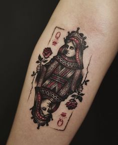 a tattoo on the arm of a woman with a queen playing card in her hand