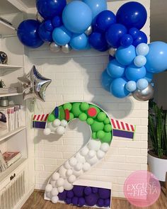 the number two balloon arch is decorated with blue, green and white balloons for a birthday party