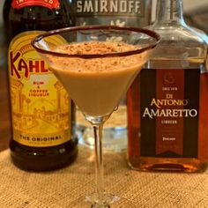 an alcoholic drink and some liquor bottles on a table