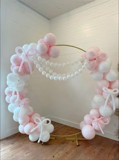 a balloon arch decorated with pink and white balloons