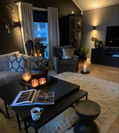 a living room filled with lots of furniture and candles on top of a coffee table