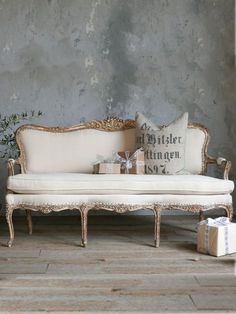 a white couch sitting on top of a hard wood floor next to a christmas tree