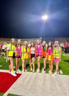 a group of girls in neon vests standing on a field