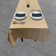 a long table with two plates and silverware on it, set up for an event