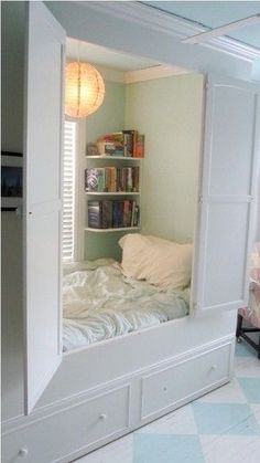 a bedroom with a bed, bookshelf and bookcase in the reflection of a mirror