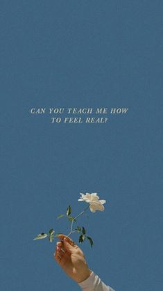 a person holding a flower in front of a blue sky with the words can you teach me how to tell real?