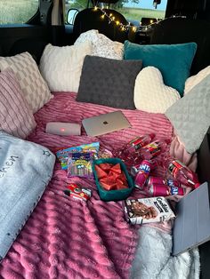 an open car trunk filled with various items including snacks, books and other personal belongings