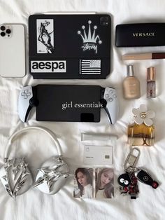 an assortment of personal items laid out on a white sheet with the name aespa