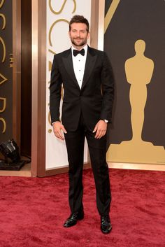 a man in a tuxedo and bow tie on the oscars red carpet