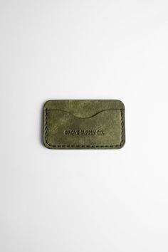 a green leather business card holder on a white background with the words growuppa co printed on it