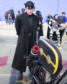 a man dressed as darth vader is standing next to a camera on a platform