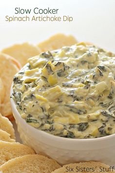 spinach dip in a white bowl surrounded by crackers