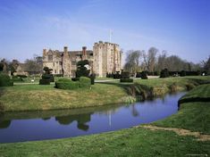 an old castle with a pond in front of it