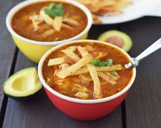 two bowls of chili cheese soup with avocado slices