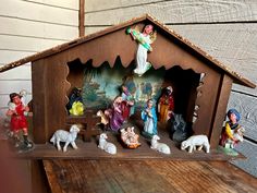 a wooden nativity scene with figurines and animals