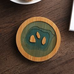 a wooden coaster that has two pieces of wood in the shape of an animal's paw