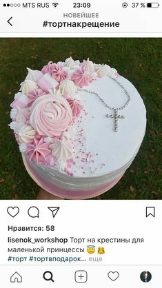 the cake is decorated with pink flowers and a cross on it's front end