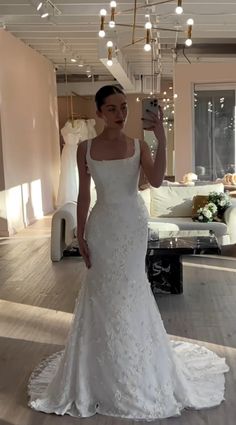 a woman in a wedding dress taking a selfie