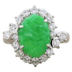 An exquisite ring featuring a 3.60 carat carved piece of natural jade. The oval shaped green jade is haloed by 0.83 carats of shimmering colorless round cut diamonds in a platinum setting. Ring Size 5.50 (Sizable) Textured Gold Ring, Jadeite Ring, Platinum Diamond Rings, Contemporary Ring, Jade Ring, Baguette Cut Diamond, Natural Jade, Platinum Ring, Three Stone Rings