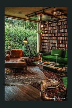 a living room filled with lots of green furniture and bookshelves full of books