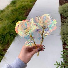 a person is holding some fake flowers in their hand and it looks like they have been painted