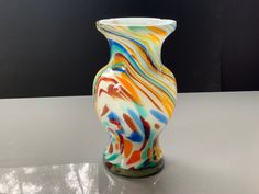 a colorful vase sitting on top of a table